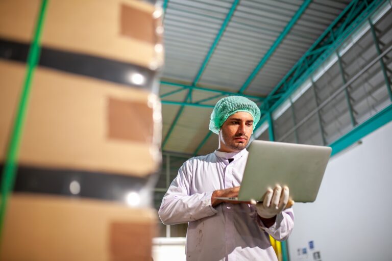 a worker typing laptop in the supplement manufacture factory.